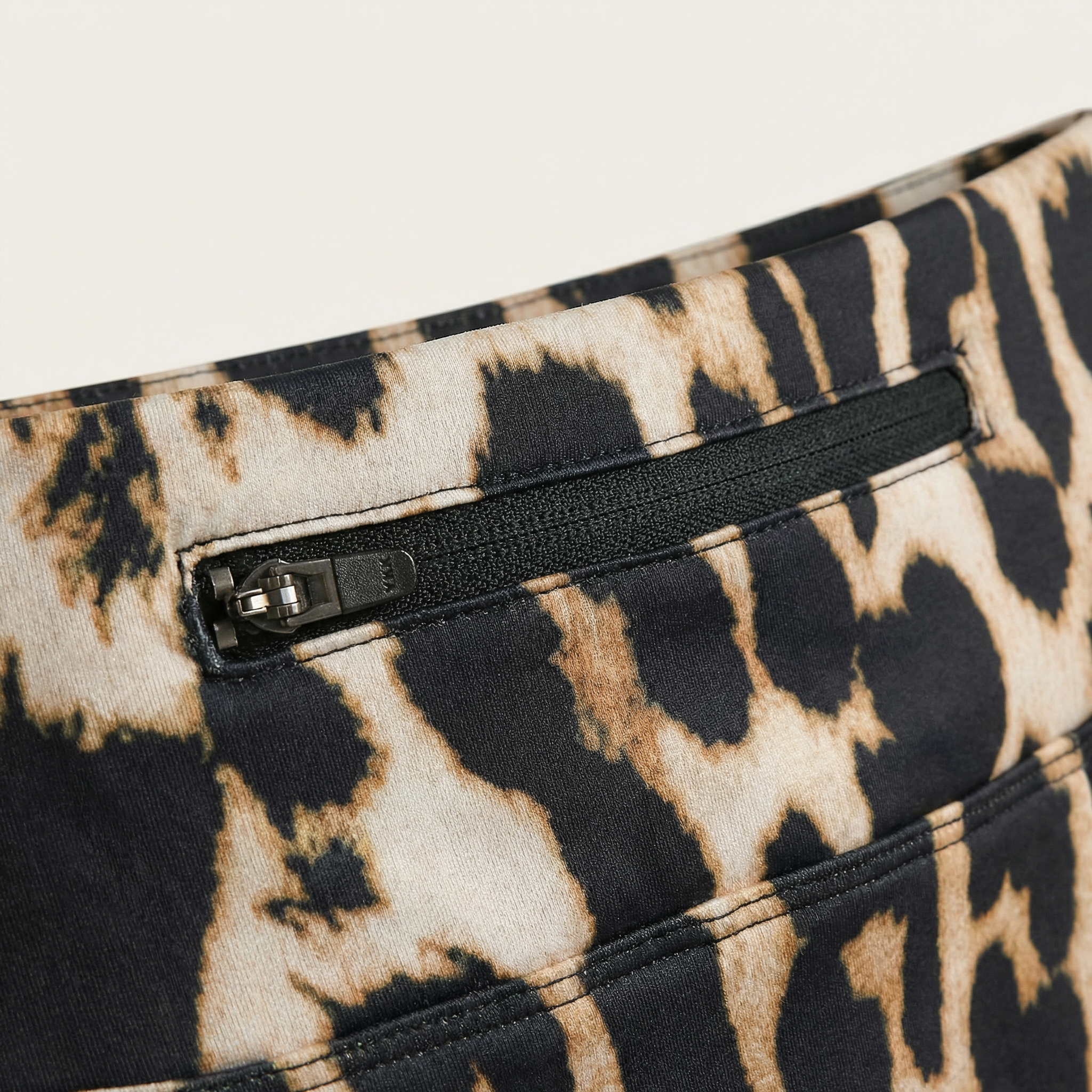 Close-up of a leopard print pattern with a zipper on a white background