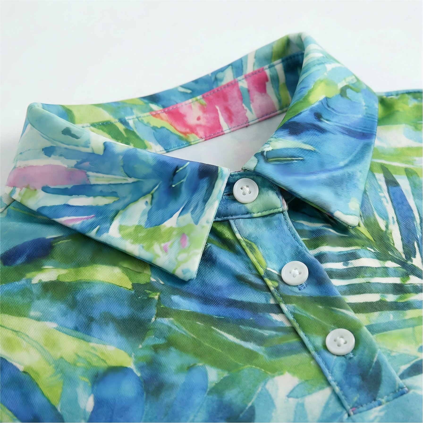 Colorful tropical leaf patterned shirt with buttons on a white background