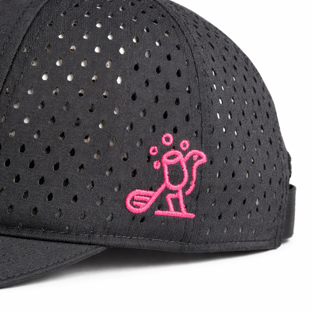 Close-up side view of Birdies & Bubbles women's black performance golf hat featuring pink embroidered golfer logo and breathable perforated fabric panels
