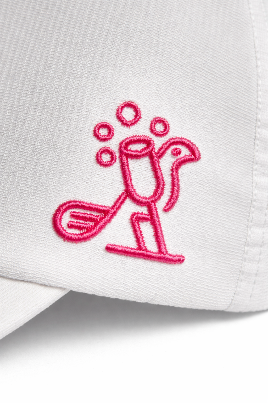 White cap with a pink embroidered flamingo design on a white background