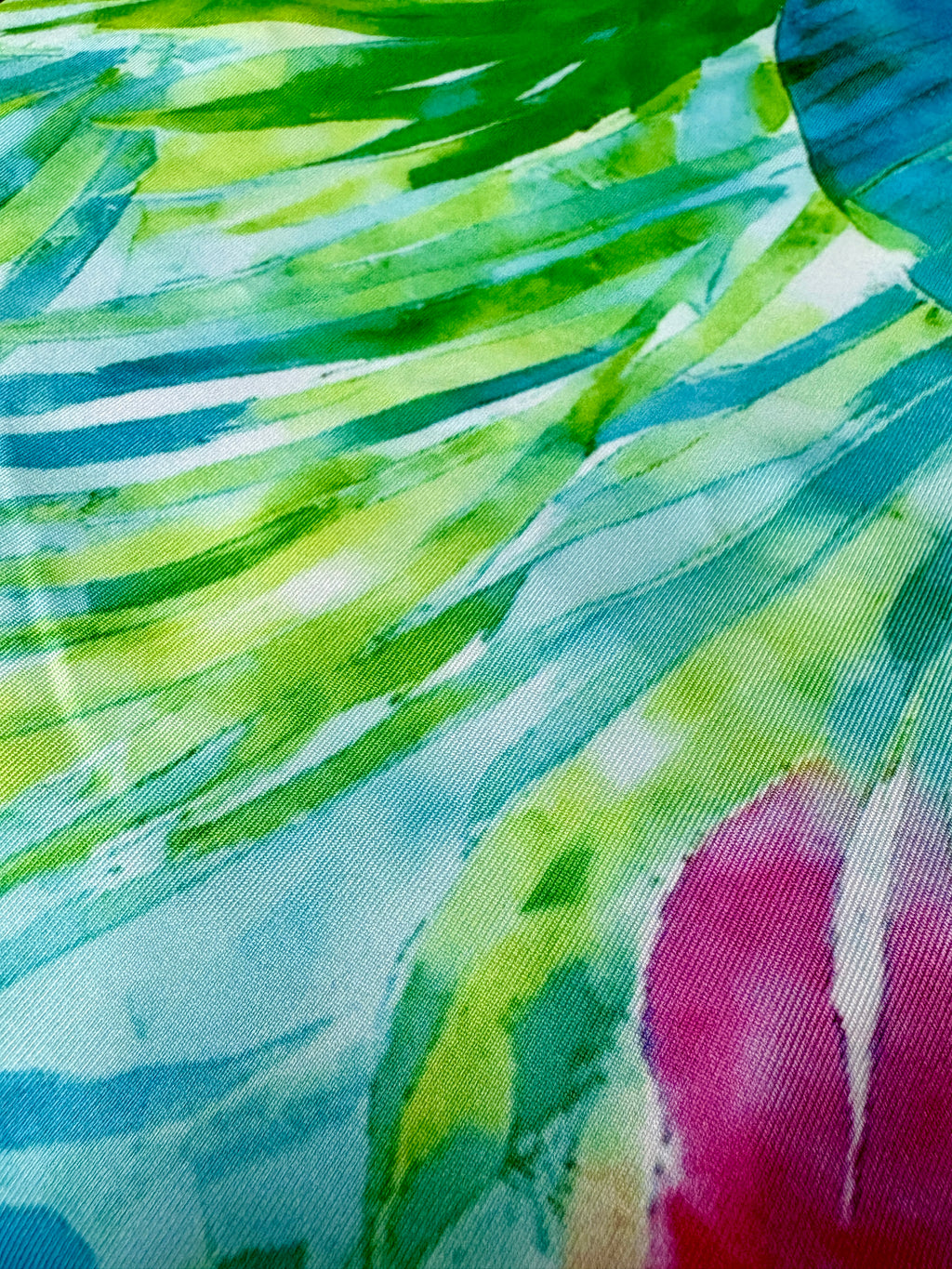 Close-up of a colorful fabric with green, blue, and pink patterns