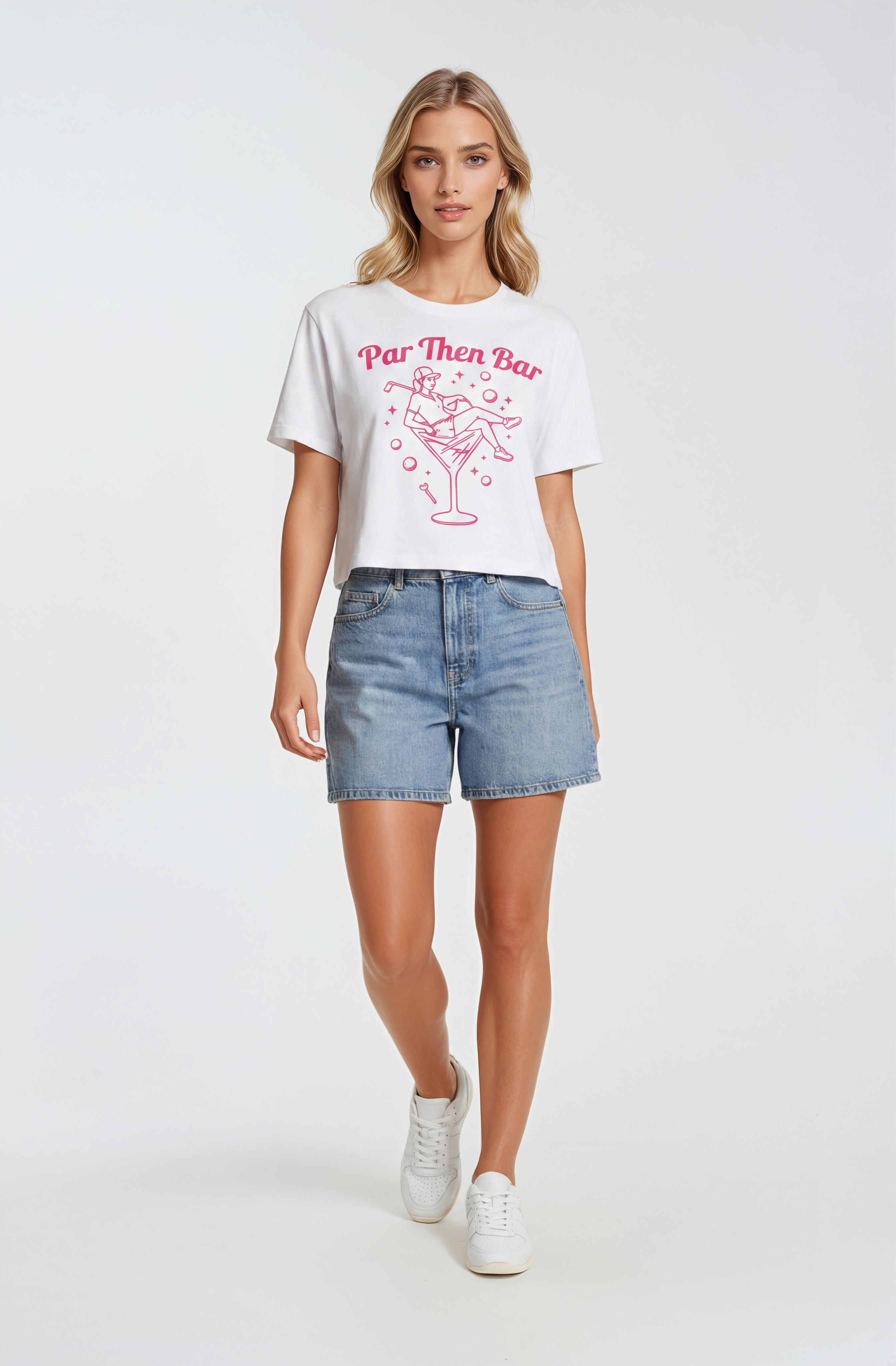 Woman wearing a white Par Then Bar t-shirt with pink text and graphics, paired with denim shorts on a white background