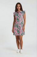 Woman wearing a Birdies and Bubbles pink dress with green leaf pattern on a white background