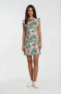 Female model wearing a pink watermelon print golf dress with green tropical leaves and ruffle sleeves