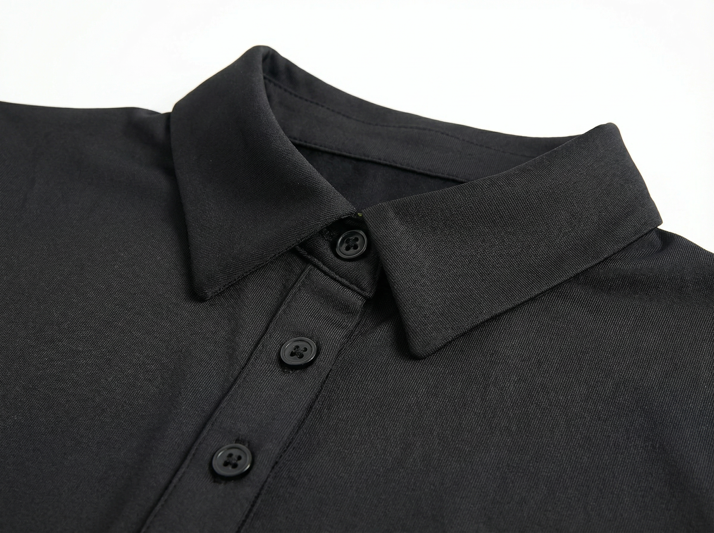 Close-up of a black polo shirt collar with buttons on a white background
