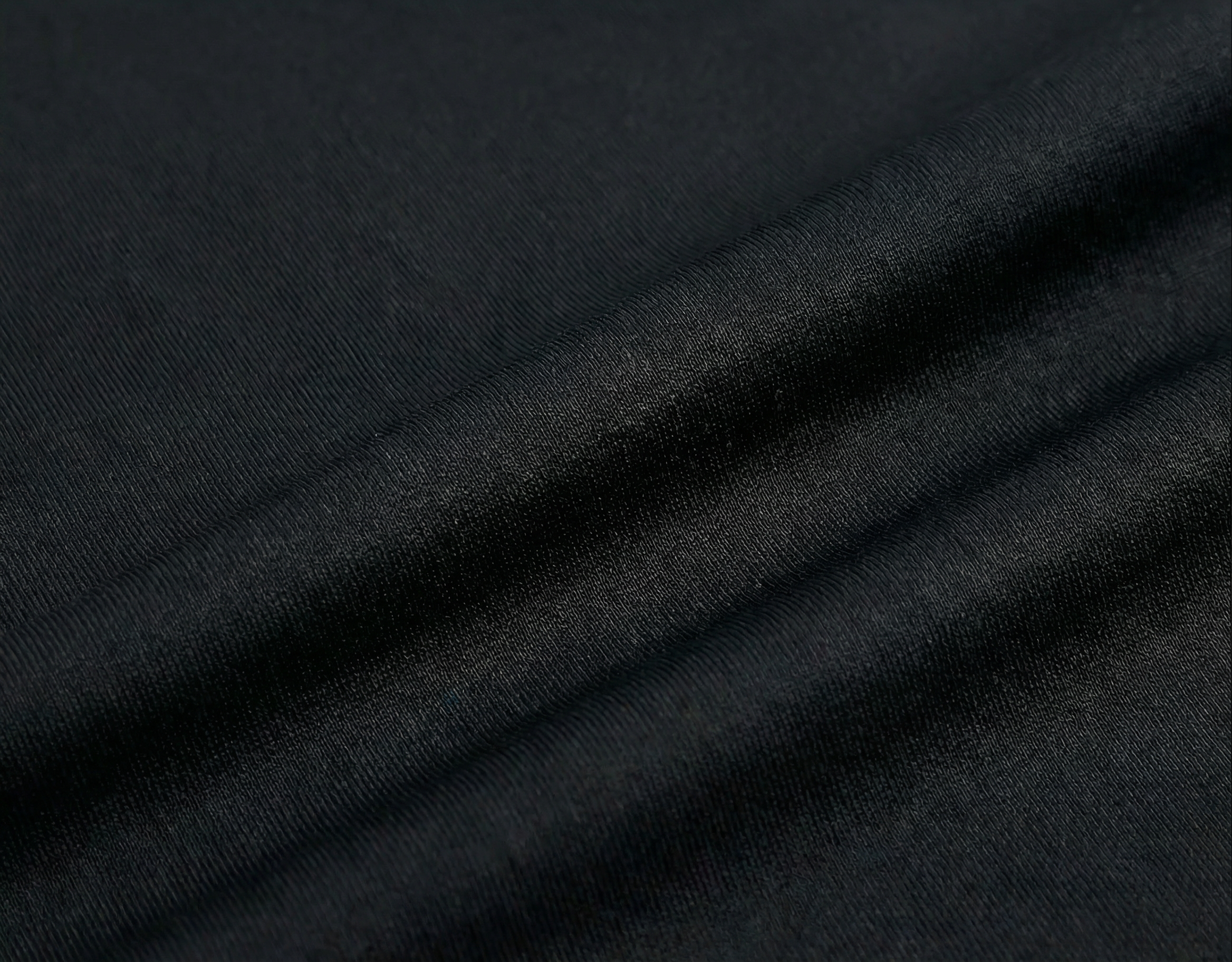 Close-up of dark black fabric with folds