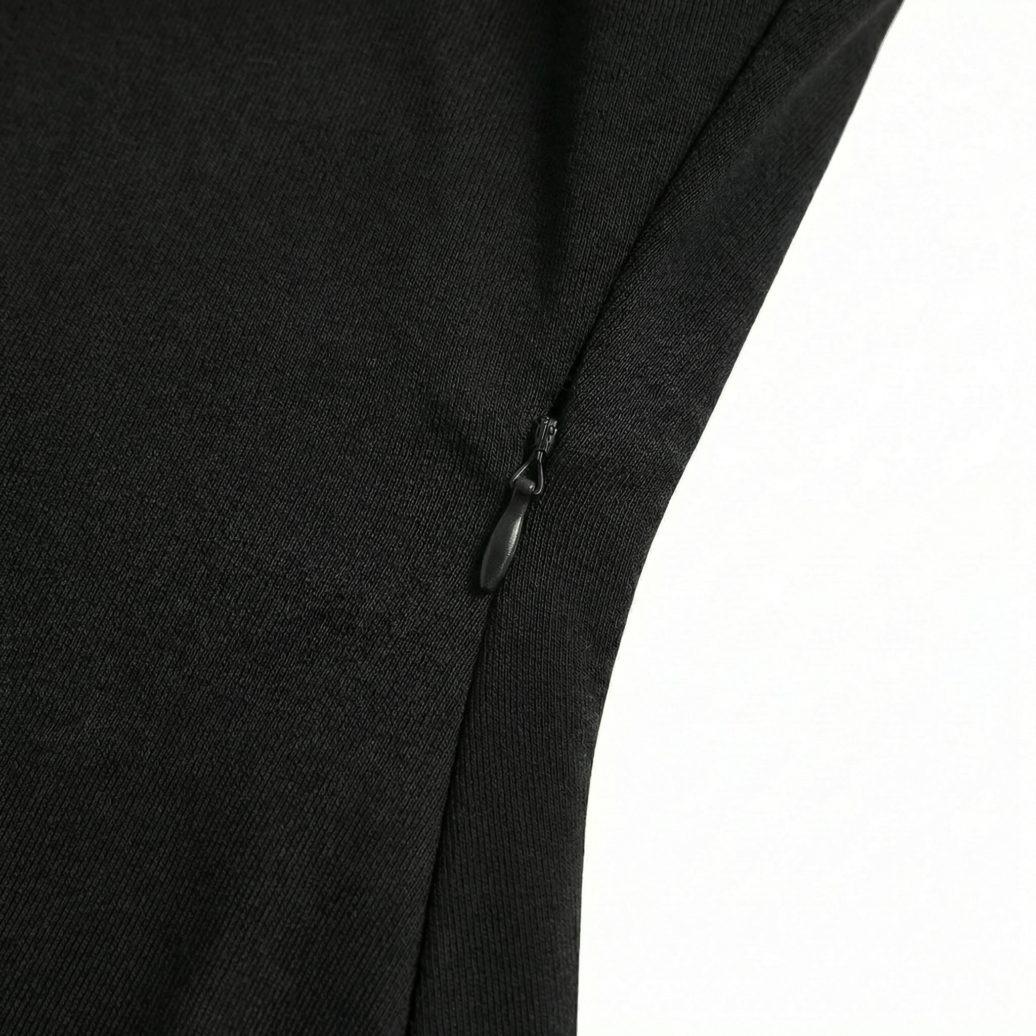 Close-up of a black garment with a zipper on a white background