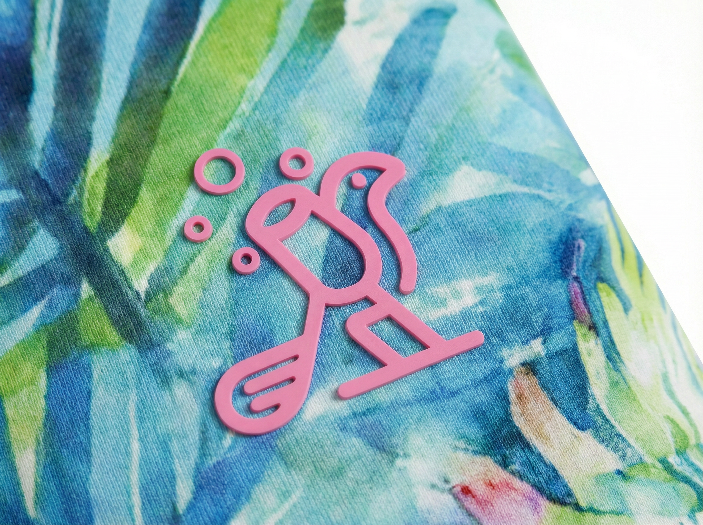 Close-up of a pink logo on a colorful fabric background