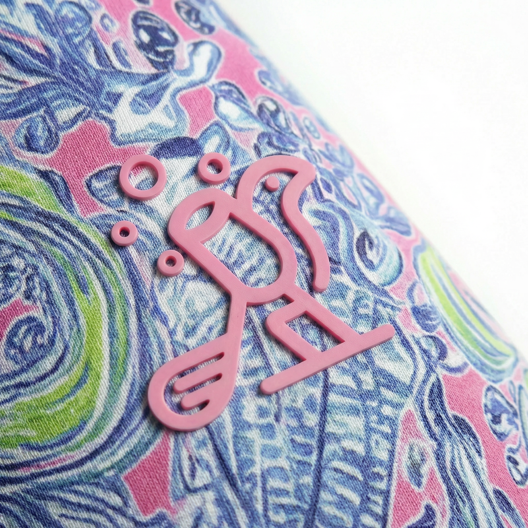Close-up of a colorful fabric with a pink 'Birdies & Bubbles' logo.
