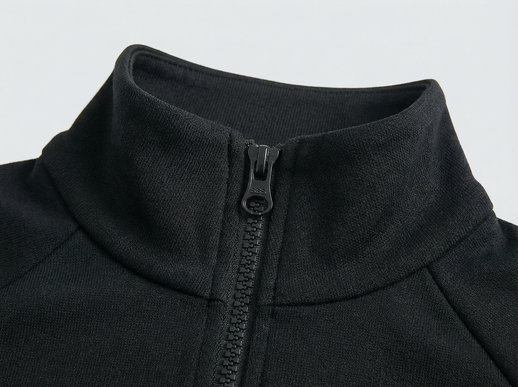 Close-up of a black jacket with a zipper on a light gray background