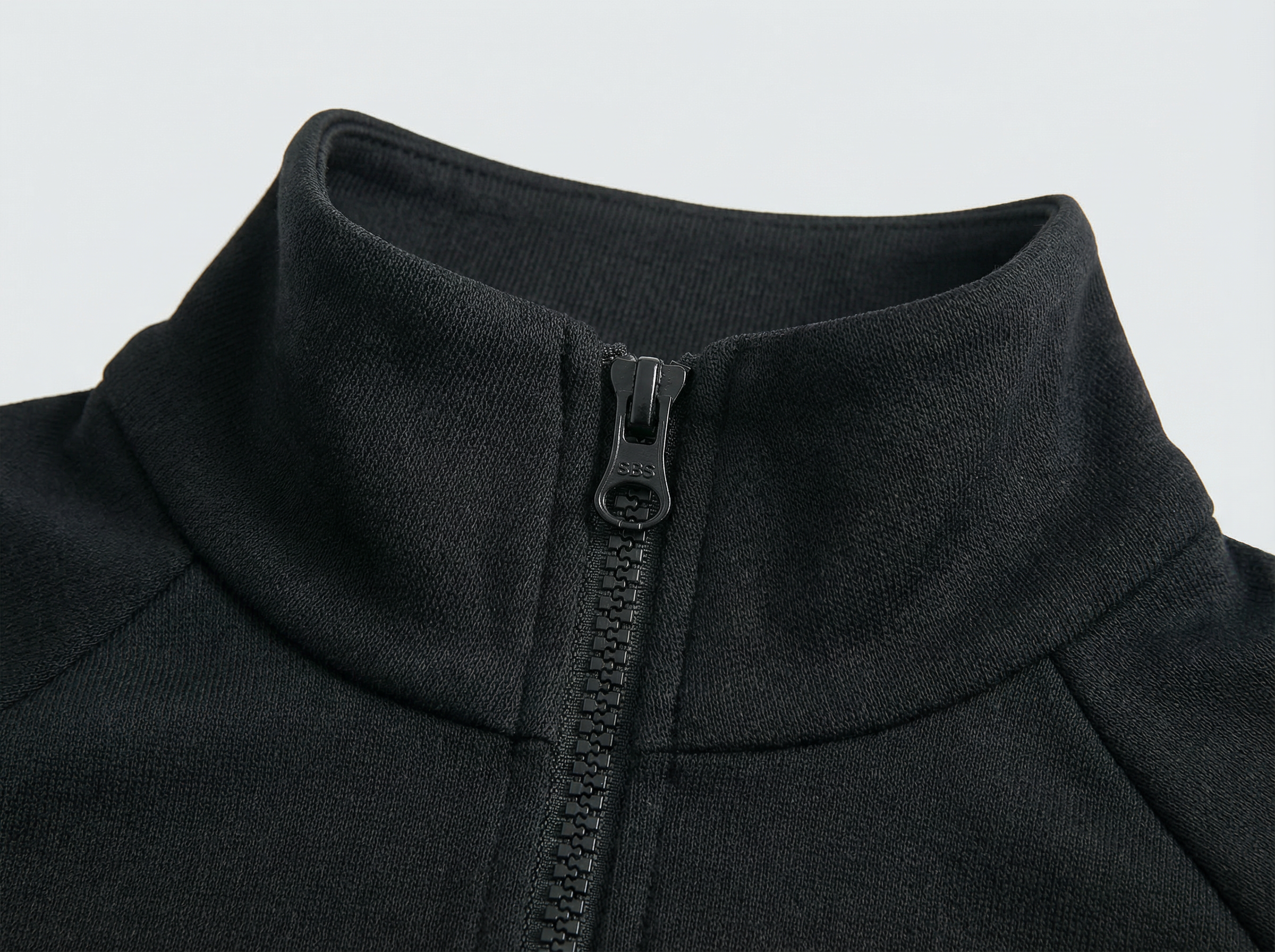 Close-up of a black jacket with a zipper on a light gray background